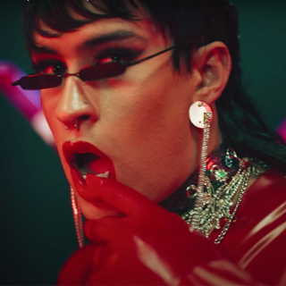 close up of bad bunny from yo perreo sola video with red lipstick a mullet and a red latex outfit